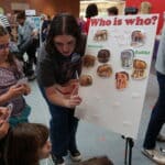 Biological sciences student Cassidy Hawkins helps children identify different types of elephants.