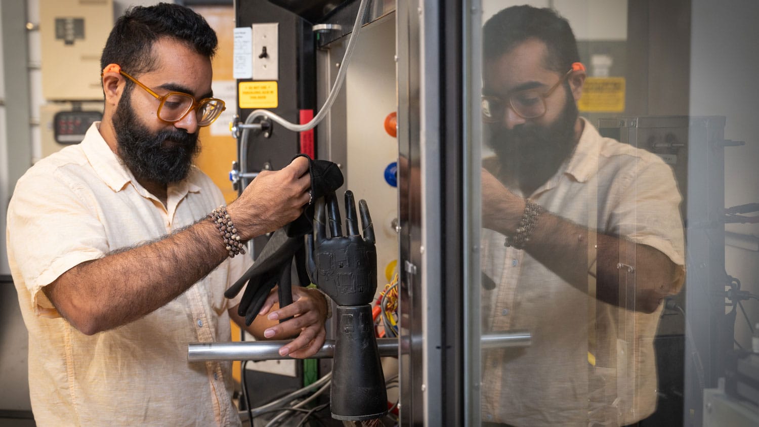Arjunsing Girase ’18, ’21, a postdoctoral researcher, conducts research using TPACC’s sweating thermal hand system to evaluate the heat and evaporative resistance of gloves.
