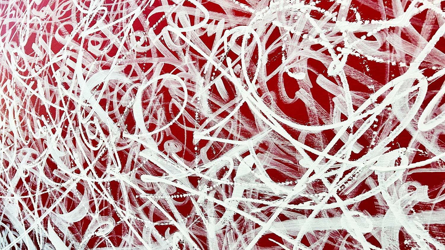 A generous amount of swirls of white paint on a red background