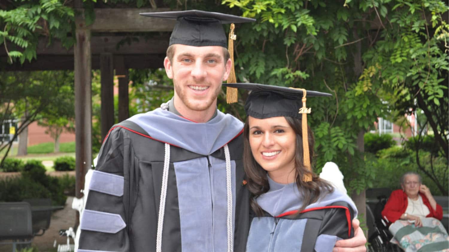 Ryan Bray and a classmate embrace after graduation.