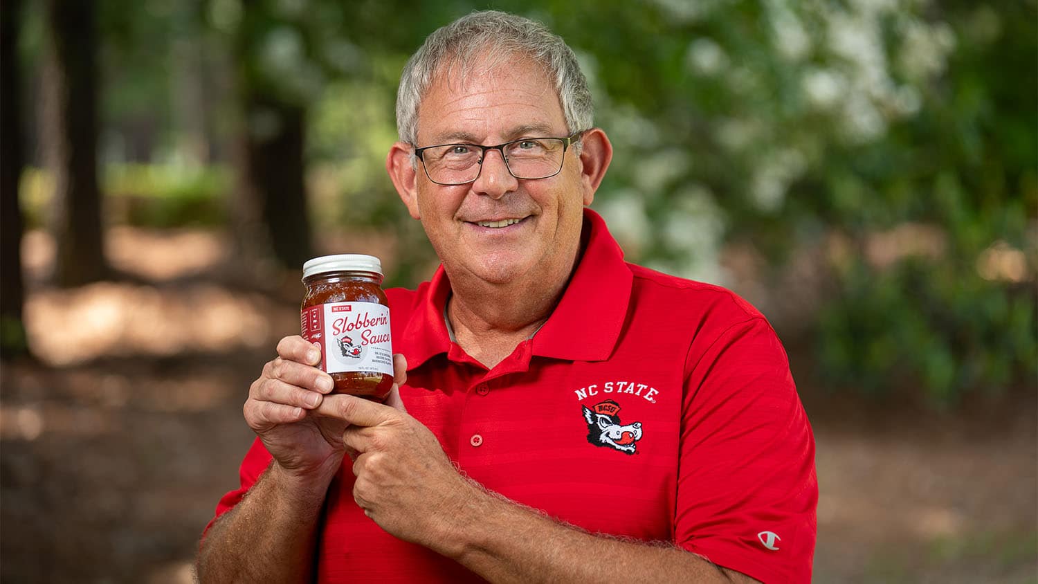 Professor Chris DePerno holds up a bottle of Slobberin' Sauce.